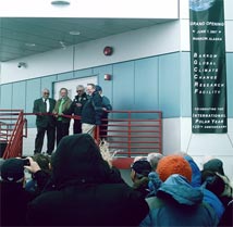 Senator Stevens (second from left) and Max Ahgeak (far left) of the Ukpeagvik Iñupiat Corporation cut a red ribbon at the building's front door to commence the new science facility's opening ceremony.