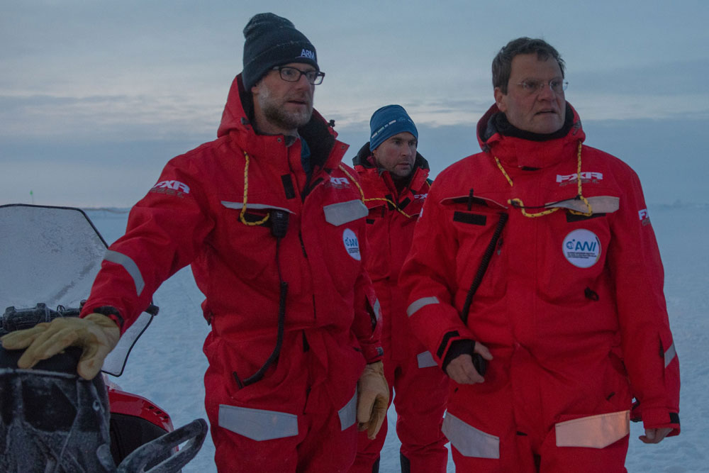From left, Matthew Shupe, Marcel Nicolaus, and Markus Rex stand on the ice floe where research took place during the 2019–2020 Multidisciplinary Drifting Observatory for the Study of Arctic Climate (MOSAiC) expedition.
