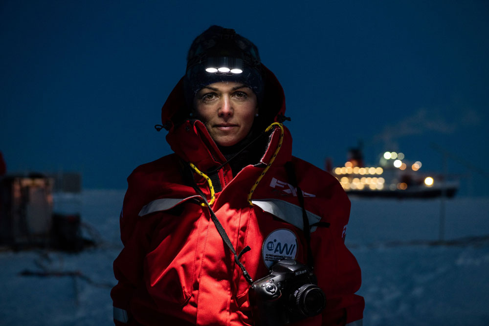 Wearing a headlamp, Esther Horvath poses in twilight for a portrait during the MOSAiC expedition.