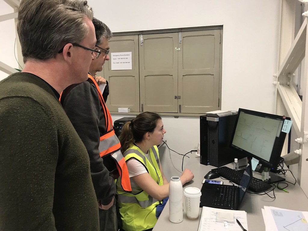 Rob Wood, Beat Schmid, and Lexie Goldberger look at data coming in on a desktop computer screen.