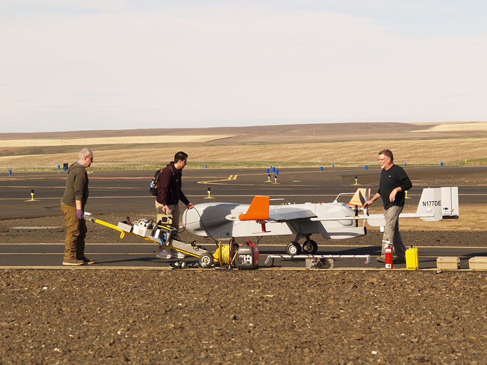 On the tarmac of the Pendleton UAS Range, ARM Aerial Facility staff work on the ArcticShark uncrewed aerial system.