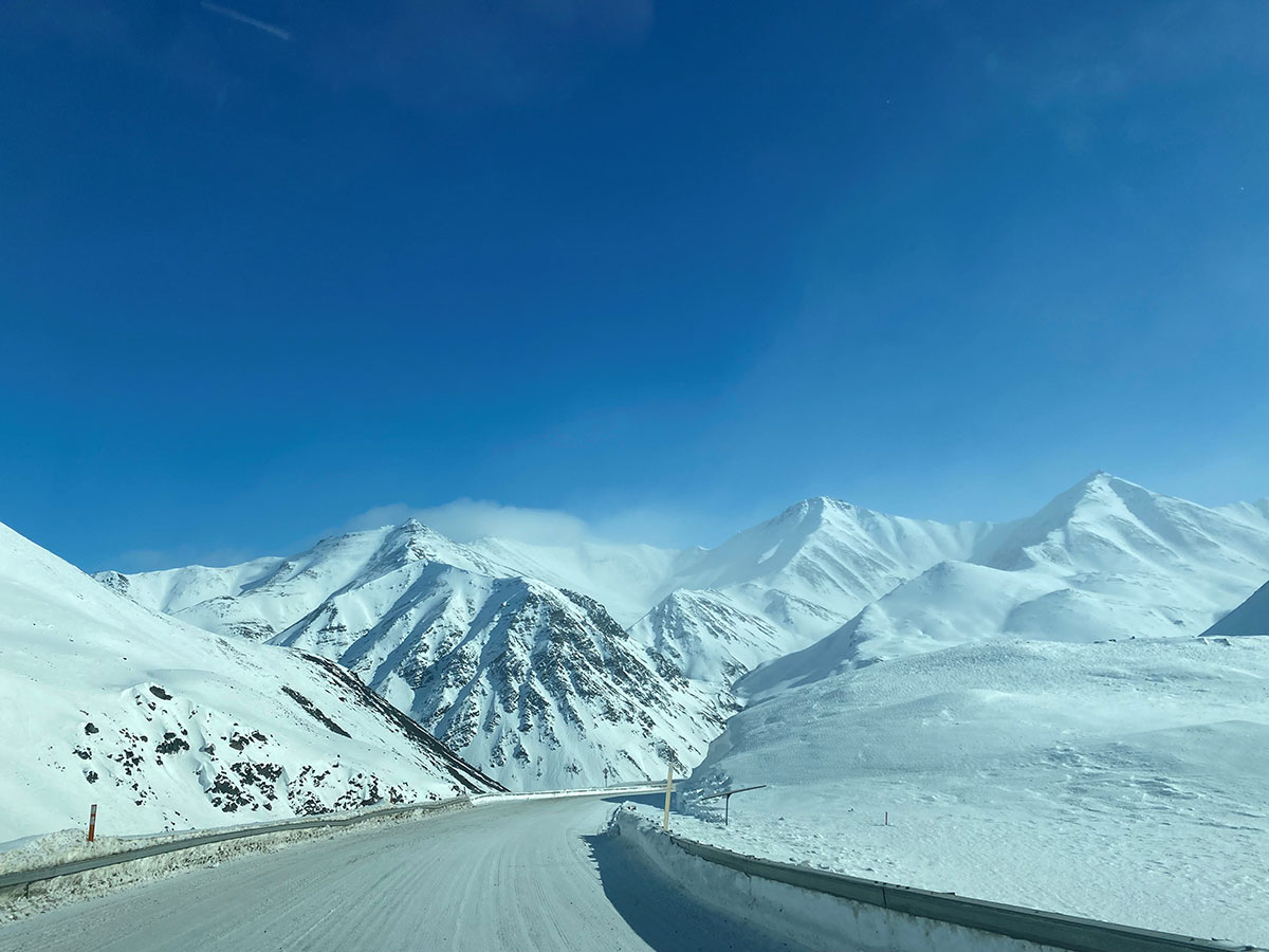 Snow-covered highway cuts into the mountains