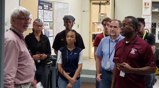 During a 2023 visit to Brookhaven National Laboratory, Daniel Vrinceanu, center right in a blue shirt, and RENEW co-investigator Bruce Prince, in front in the maroon shirt, join Texas Southern University interns for an overview of sPHENIX, a radically updated version of the Pioneering High Energy Nuclear Interaction eXperiment (PHENIX). In the pink shirt at left is presenter Ed O’Brien, assistant chair of Brookhaven's Physics Department and former director of the sPHENIX project. Photo is courtesy of Vrinceanu.