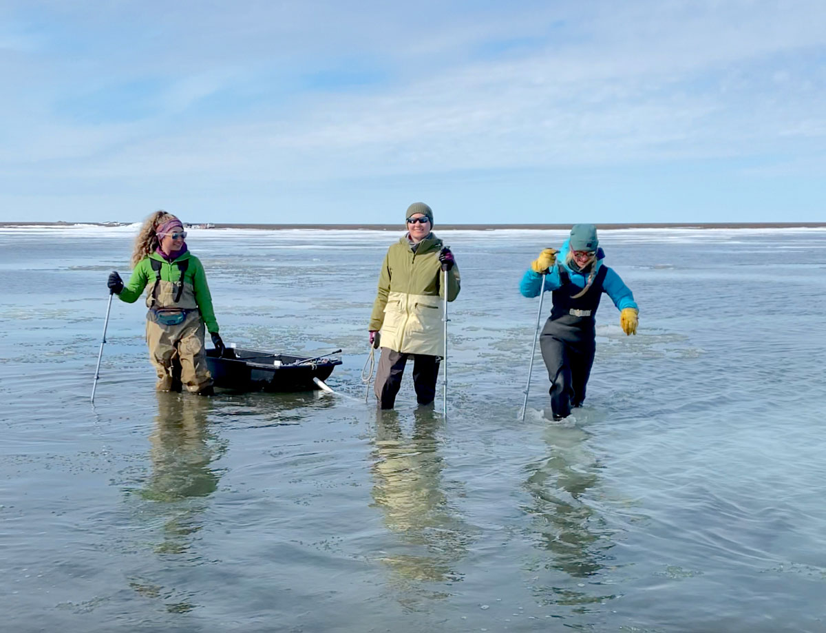 Serina Wesen, Hannah Chapman-Dutton, and Anika Pinzner make their way through knee-deep water on Elson Lagoon.