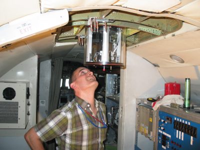 Connor Flynn looks up at the 4STAR instrument installed through the upper hull of the G-1 aircraft.