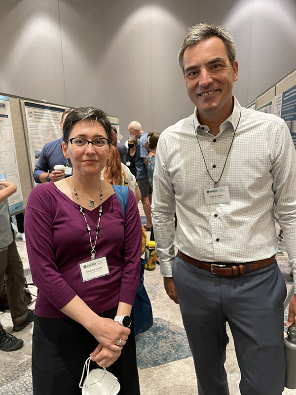 Shaima Nasiri and Gijs de Boer stand together and pose for a picture in between two rows of posters.