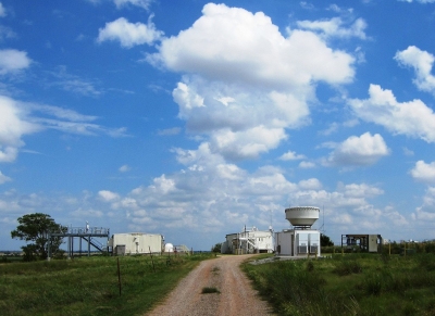 To the right, a bowl-like Ka-Band ARM Zenith Radar (KAZR) at the ARM Southern Great Plains atmospheric observatory points upward to retrieve a straw-like “zenith” profile of clouds.