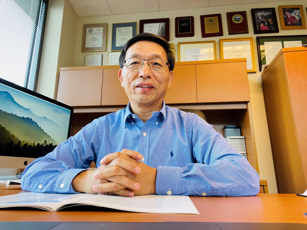 Zhanqing Li pauses for a picture while seated in his office.