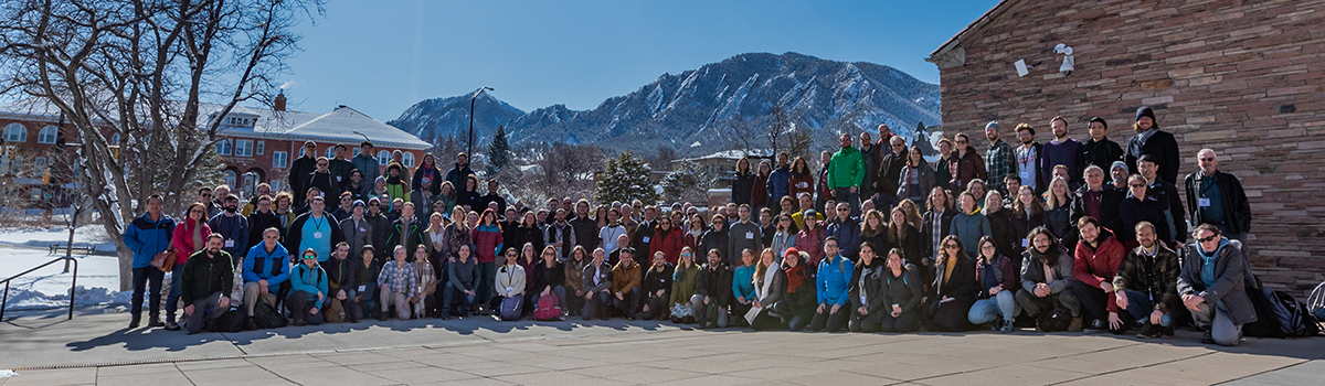 Participants in the Second International MOSAiC Science Conference gather for a group picture with a mountain peak appearing in the distance.