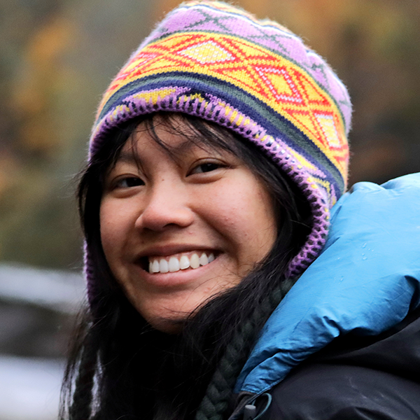 Wearing a knit winter hat with strings, Alexandra Ng turns her head to the left for a picture.