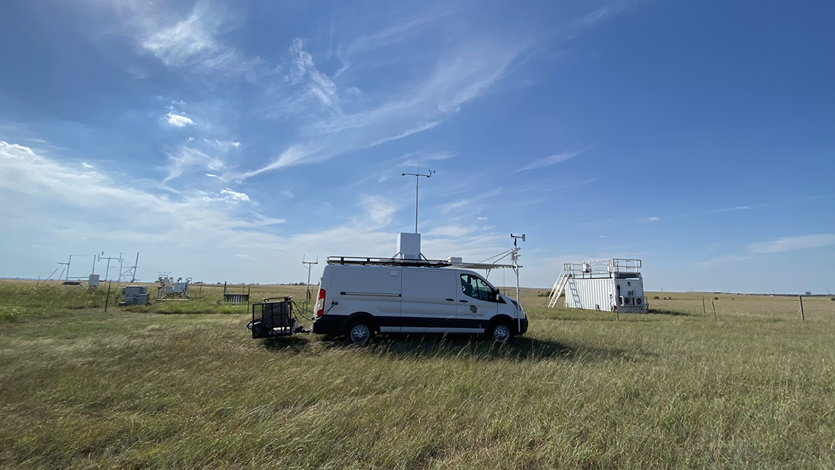 A white van is parked near an ARM instrument field.