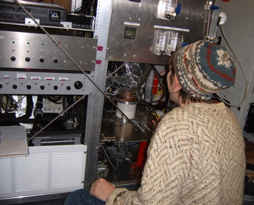 Sarah Brooks looks at instrumentation on a large metal cart.