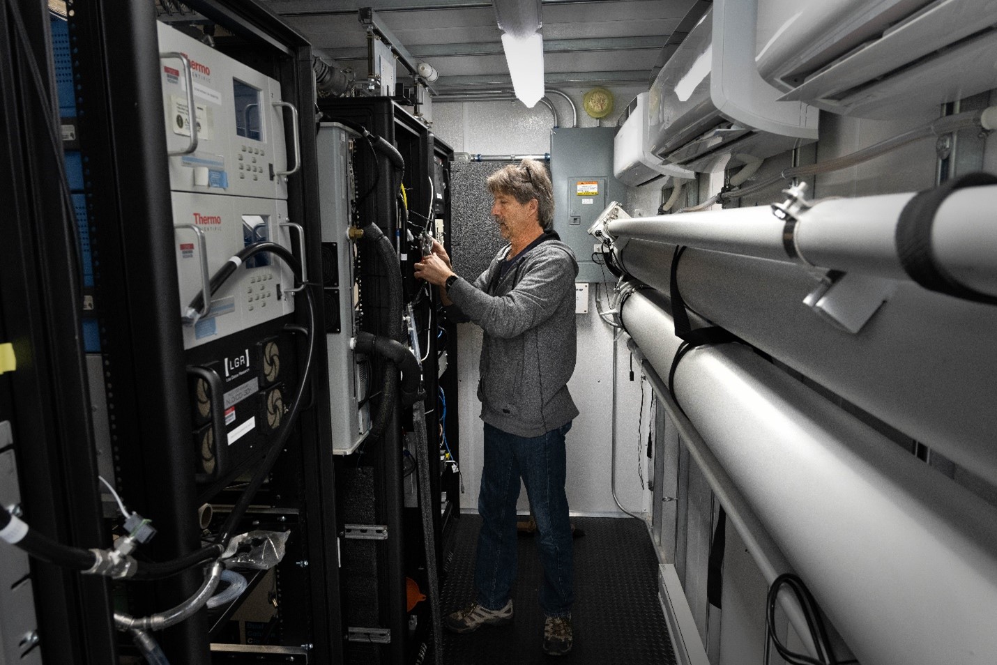 Scott Smith works inside an Aerosol Observing System.