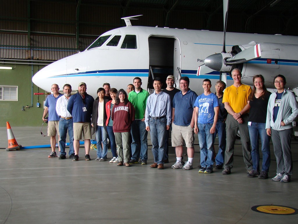 Researchers stand in front of the open door of ARM's G-1 research aircraft