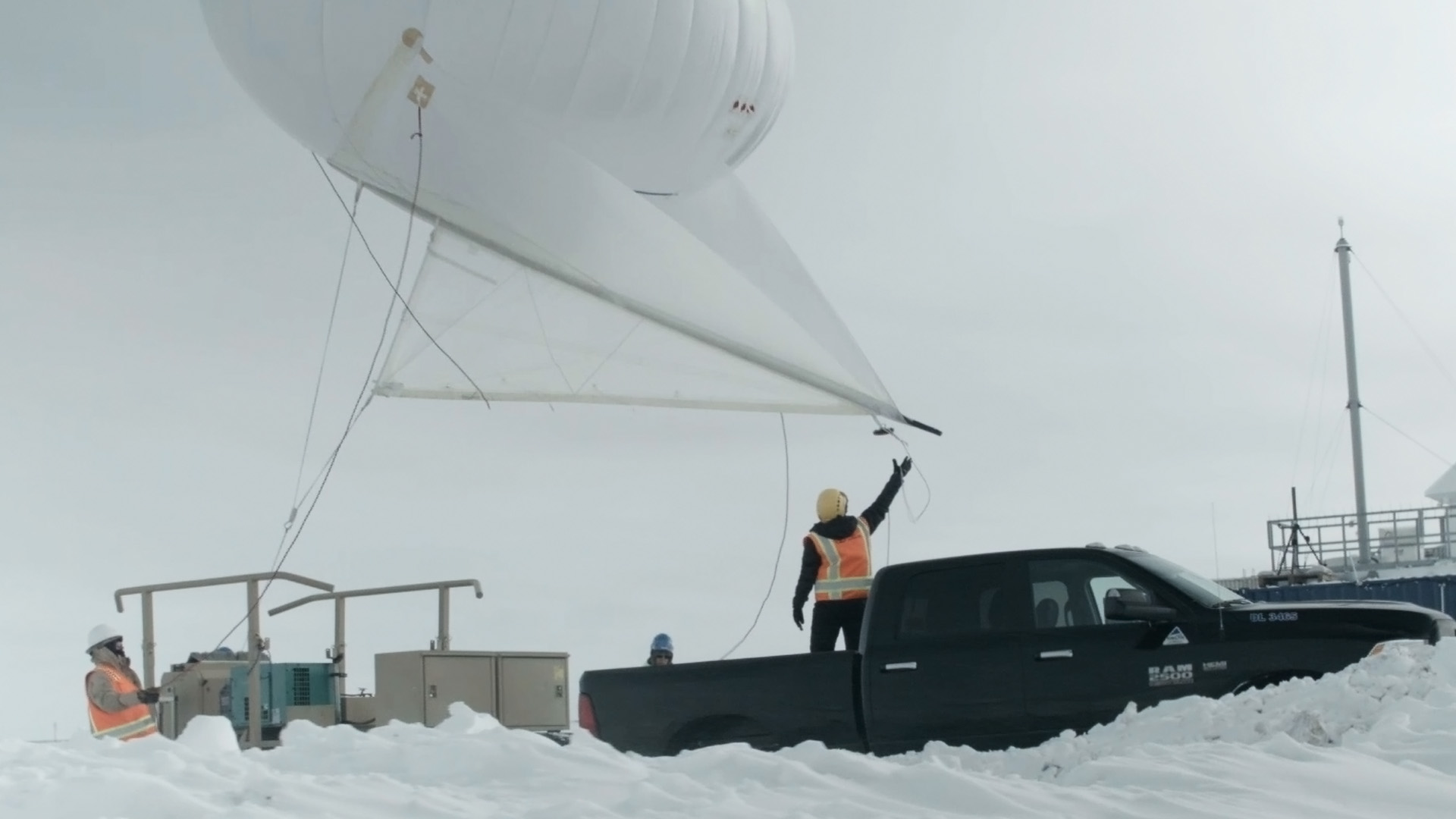 From the bed of a pickup truck, Dari Dexheimer lets go of a tethered balloon.