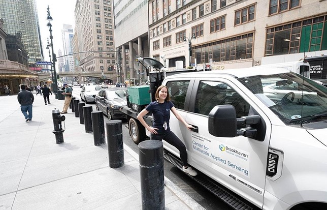 On a New York City sidewalk, Katia Lamer stands next to an instrumented truck.