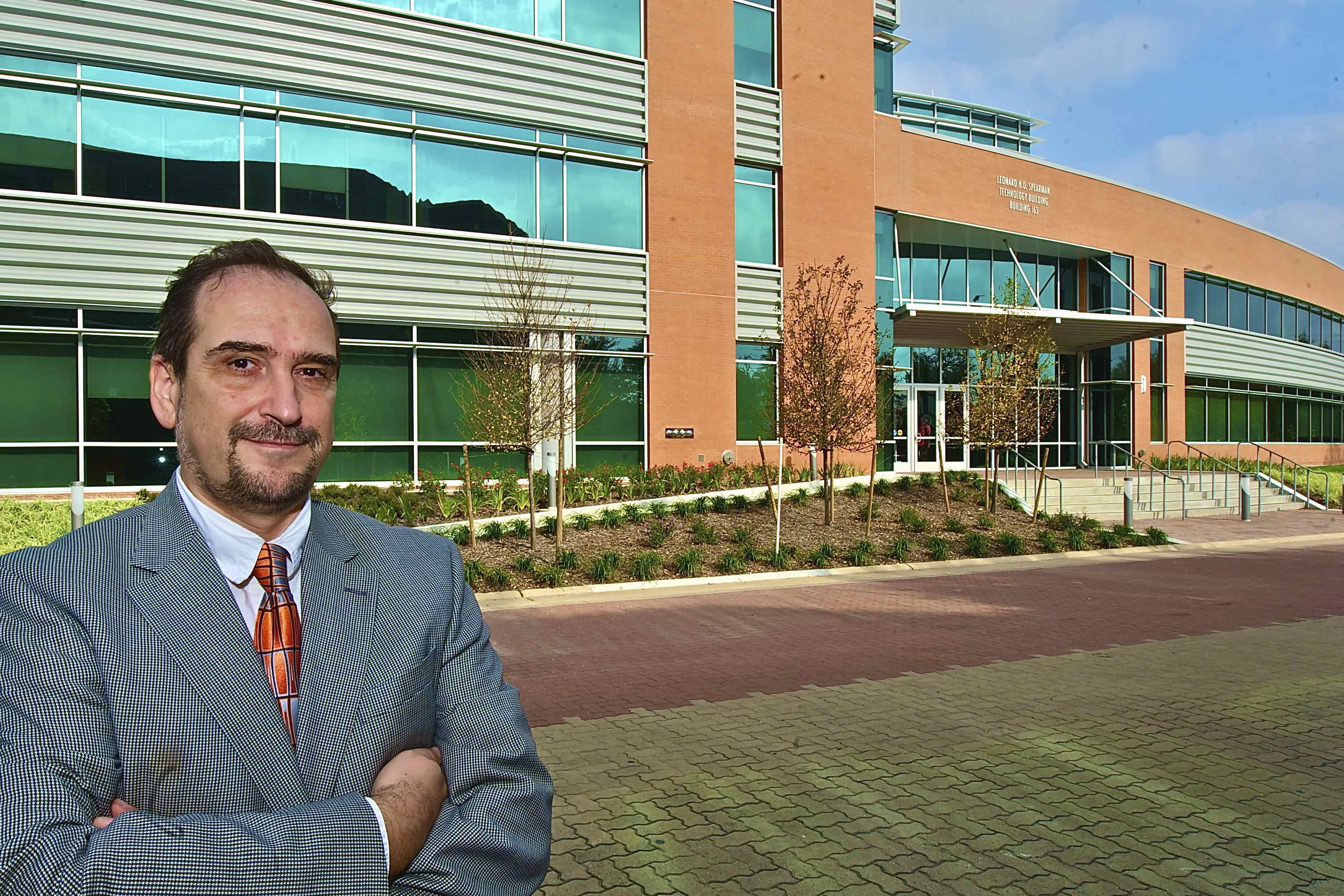 Daniel Vrinceanu stands with his arms crossed and a relaxed closed-mouth smile outside the Leonard H.O. Spearman Technology Building at Texas Southern University. Photo is courtesy of Vrinceanu.