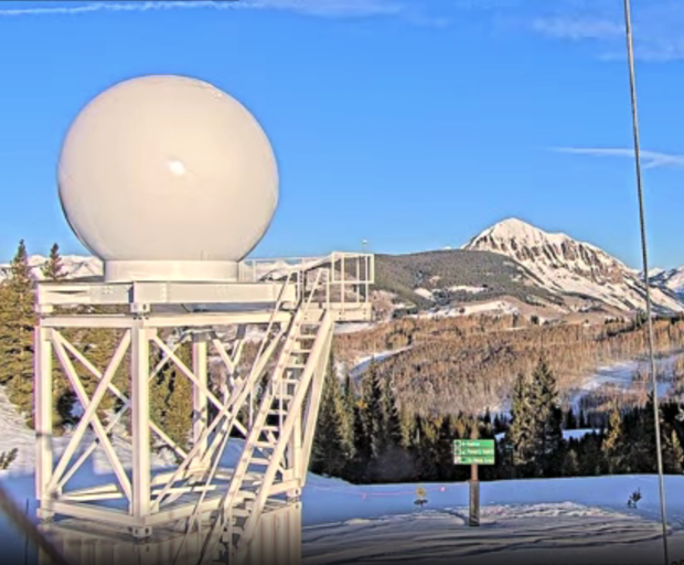 Snow covers the ground in front of the Colorado State University X-band radar.