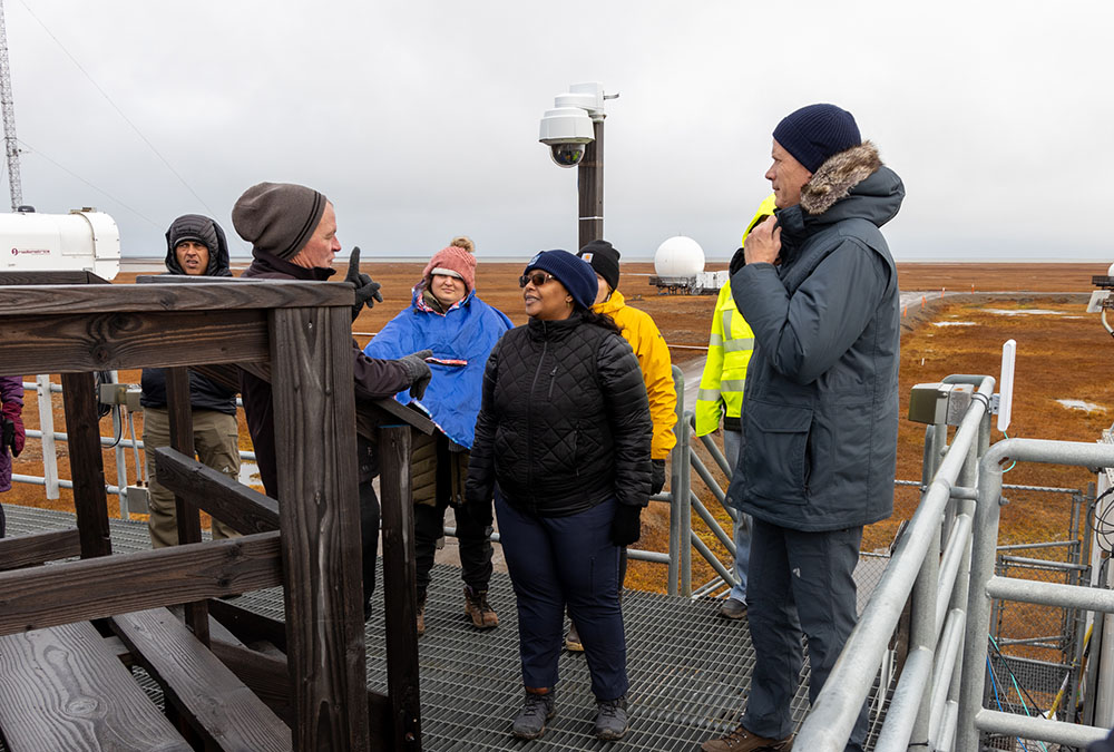 Mark Ivey talks with DOE Office of Science Director Asmeret Asefaw Berhe on an instrument platform overlooking tundra along Alaska's North Slope.