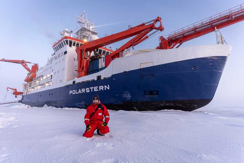 Janek Uin in front of the Polarstern icebreaker during the MOSAiC expedition