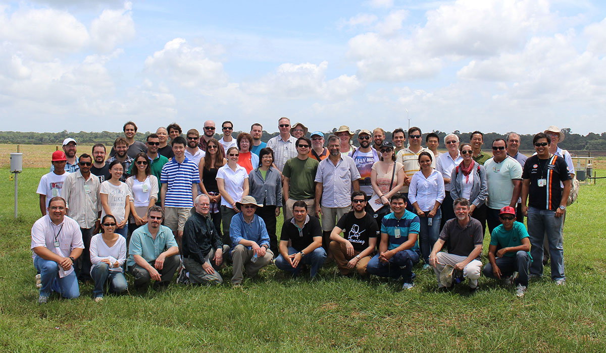 A group of people stands together in an instrument field.