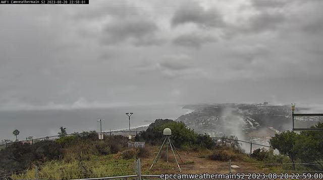 A camera trained on the Pacific Ocean and Ellen Browning Scripps Memorial Pier in La Jolla, California, captures clouds moving during Tropical Storm Hilary. EPCAPE instruments on Mount Soledad, including a disdrometer and rain gauge, are in the foreground.
