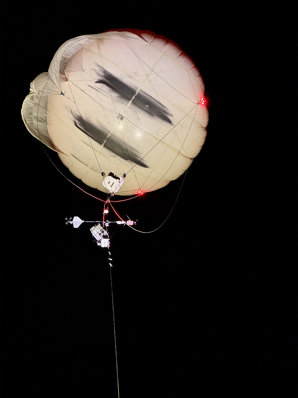 Red lights illuminate the ARM tethered balloon system to keep it visible at night. 