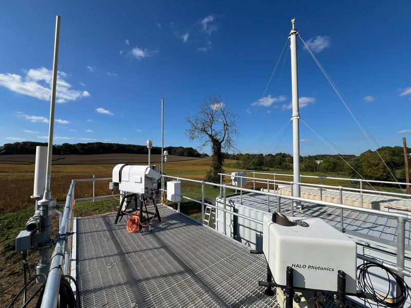 Instruments are on a container rooftop next to the ARM Aerosol Observing System and its stack.